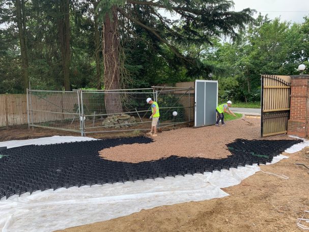 Image of tree with barrier around it  for protection as Men work around it creating a driveway